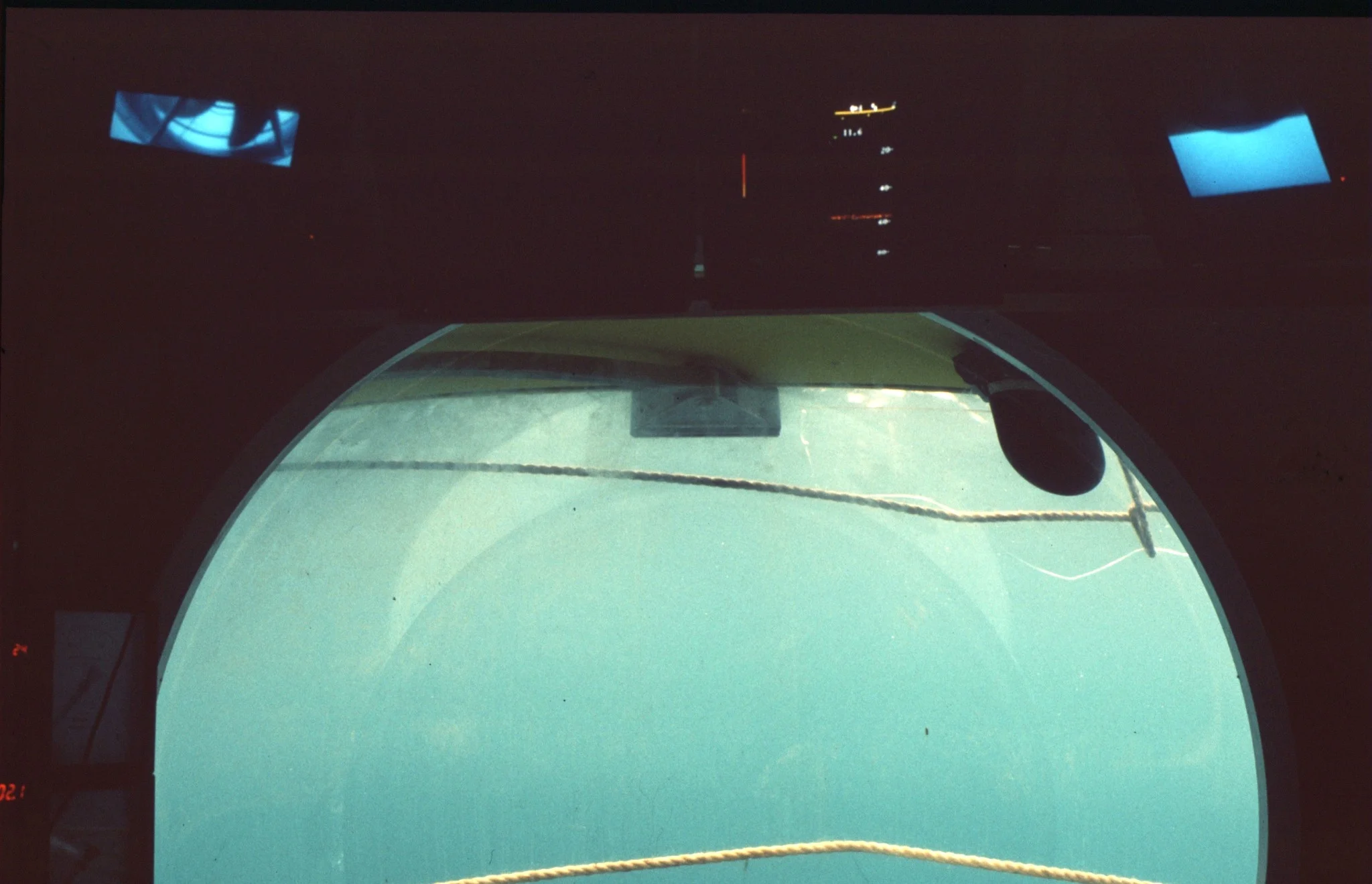 Cockpit rouillé du sous-marin Iron Lung avec écran radar et contrôleurs minimalistes.