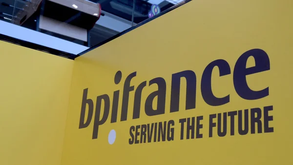 Mur d'exposition jaune avec le logo de Bpifrance et le slogan 'SERVING THE FUTURE'