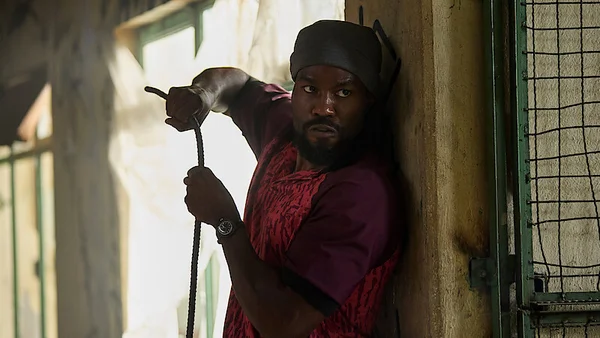 Yahya Abdul-Mateen II, incarnant John Creasy, barbu et coiffé d'un couvre-chef, s'appuyant contre un mur en tenant une corde dans la bande-annonce de la série Man on Fire.