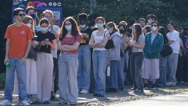 File d'attente d'étudiants portant des masques faciaux devant le bâtiment du syndicat étudiant de l'Université du Kent, faisant la queue pour se faire vacciner contre la méningite après une épidémie ayant causé au moins deux décès.