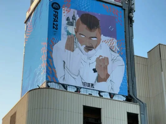Fresque géante du rappeur Jul dans le 16e arrondissement de Marseille, avec une publicité pour le jeu vidéo FIFA 22 sur un immeuble.