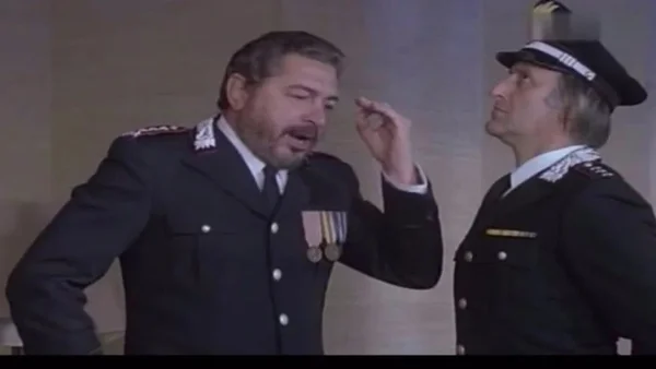 Extrait vidéo de faible résolution montrant deux hommes en uniforme de police, l'un barbu gesticulant en parlant à l'autre, dans une scène du film italien I Carabbinieri.