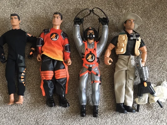 Quatre figurines d'action de la série Jonny Quest (Jonny, Race Bannon, Hadji et le professeur Quest) alignées sur un tapis beige