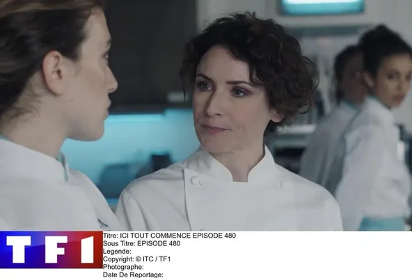 Image extraite de la série « Ici tout commence » montrant Elsa Lunghini en tenue de chef cuisinier, discutant dans une cuisine avec une autre femme.