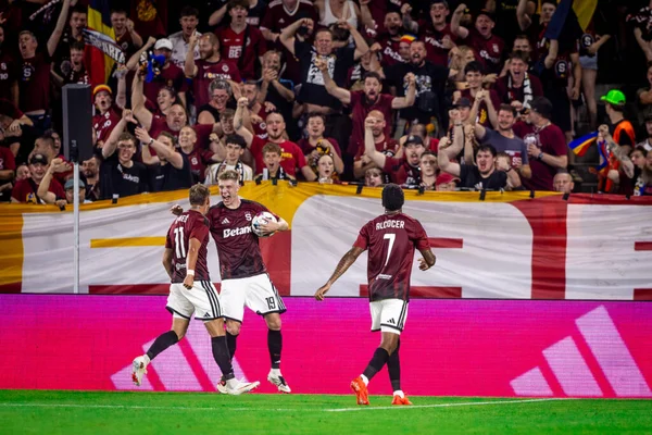 Joueurs du Sparta Prague célébrant leur victoire 2-1 contre l'Olympique Lyonnais lors du barrage de Ligue des champions, avec le ballon et les supporters en arrière-plan.