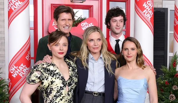 Michelle Pfeiffer et ses partenaires du film 'Oh. What. Fun.' posant devant une porte rouge et des décorations de cannes de bonbon lors de l'avant-première à New York.