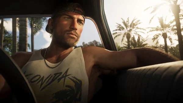 Capture d'écran de gameplay de Grand Theft Auto VI montrant le protagoniste Jason Duval assis au volant d'une voiture, avec des palmiers visibles à travers la vitre.