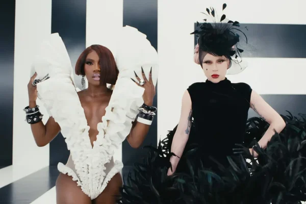 Lady Gaga et Doechii posant en tenues haute couture noir et blanc lors du tournage du clip 'Runway', avec une combinaison blanche à volants et une robe noire à plumes