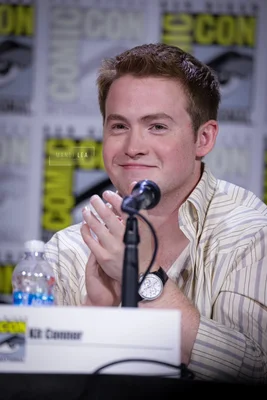 Kit Connor, acteur pressenti pour incarner Cyclope dans le reboot X-Men, souriant lors d'un panel au Comic Con de San Diego, vêtu d'une chemise à rayures, les mains jointes près d'un micro.