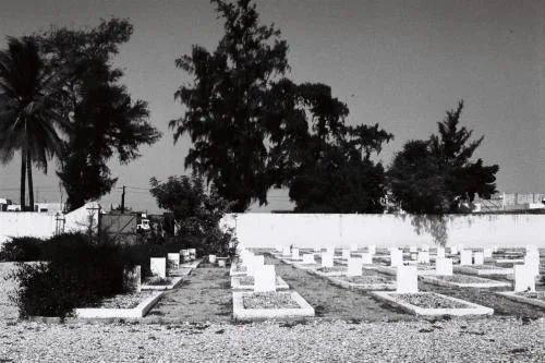 Cimetière de Thiaroye avec des rangées de stèles blanches, photographié en noir et blanc, témoignant du massacre des tirailleurs sénégalais du 1er décembre 1944