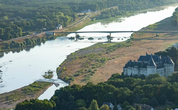 Vue aérienne de la Loire à sec avec de vastes bancs de sable exondés, un pont moderne enjambant le fleuve et le château de Saumur sur la rive droite, illustrant un étiage saisonnier normal.