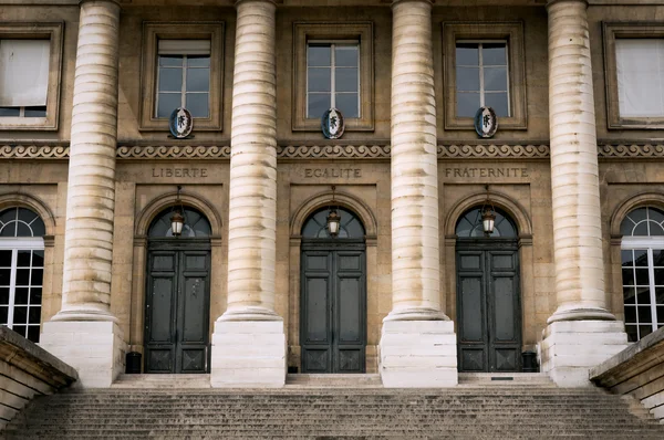Façade néoclassique du Palais de Justice de Paris avec ses grandes colonnes cannelées et ses trois portes cintrées gravées de la devise 'LIBERTE EGALITE FRATERNITE'