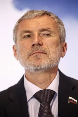 Portrait d'Alexeï Jouravliov, député russe et président du parti Rodina, en costume sombre et cravate à motifs, regardant hors champ.