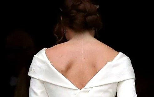 La princesse Eugenie vue de dos dans sa robe de mariée blanche dévoilant sa cicatrice, lors de son mariage en 2018.