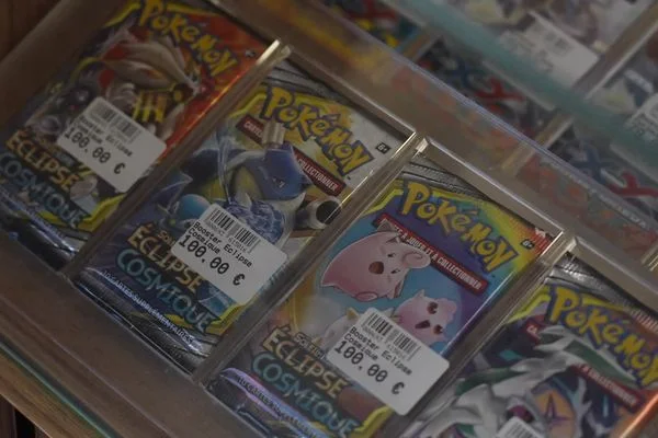 Cartes Pokémon de l'extension Eclipse Cosmique, encapsulées dans des boîtiers de protection et exposées dans une boutique spécialisée à Bourgoin-Jallieu, après le vol de 80 000 euros de cartes.