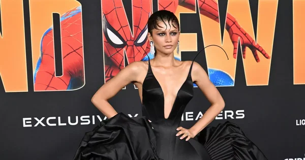 Zendaya sur le tapis rouge de l'avant-première parisienne de Spider-Man: Brand New Day, portant une robe noire à décolleté plongeant et jupe volumineuse, devant un décor promotionnel à l'effigie de Spider-Man.