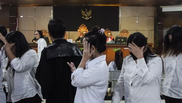 Des prévenus quittent le tribunal de district de Bandung après une audience dans une affaire de trafic de bébés, en Indonésie.