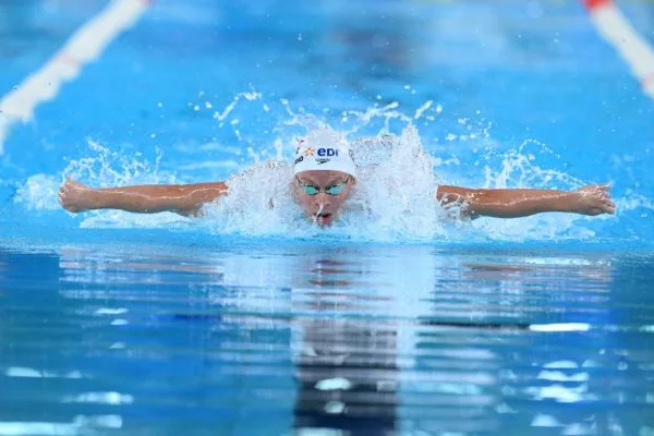 Léon Marchand, champion d'Europe du 200 m papillon, célèbre sa victoire en finale, une médaille d'or à la main, dans le bassin olympique.