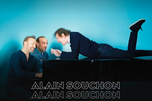 Alain Souchon et ses fils en concert au Casino de Paris en novembre 2024, assis autour d'un piano noir lors d'une représentation promotionnelle