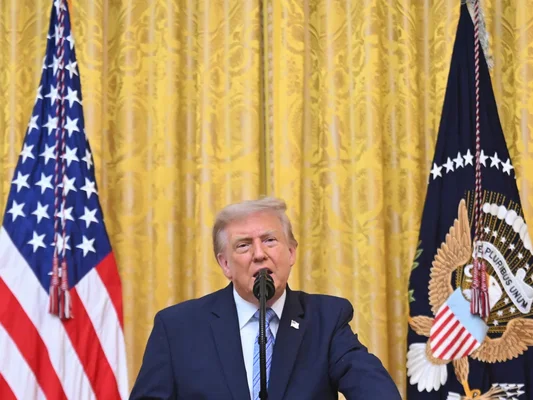 Donald Trump en costume sombre s'adressant à la presse lors d'une conférence sur la sécurité électorale, illustrant ses déclarations de déni des résultats