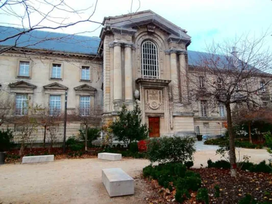Façade du Palais de Justice de Reims, bâtiment de pierre claire avec drapeaux français, lieu où s'ouvre le procès des chirurgiens de Corentin, 11 ans.