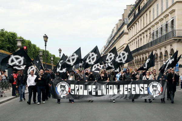 Manifestants marchant dans une rue avec des drapeaux noirs et une banderole « GROUPE UNION DEFENSE » lors d'une manifestation du GUD, organisation d'extrême droite dont Gabriel Loustau est un chef.
