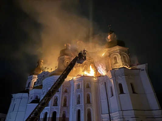 La cathédrale de la Dormition du monastère des Grottes de Kyiv en flammées après l'attaque russe du 15 juin 2026, avec des camions de pompiers intervenant la nuit