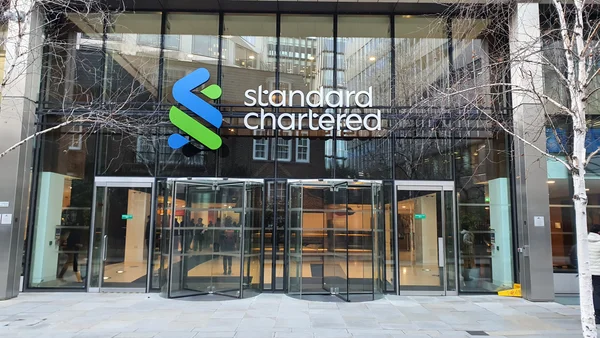 Façade principale du siège londonien de la banque Standard Chartered, un bâtiment moderne en verre et acier.