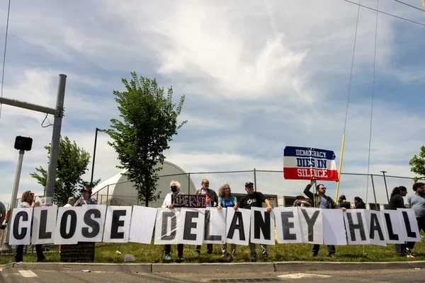 Manifestation de protestation devant une installation de l'ICE dans le New Jersey, illustrant le contexte des affrontements où des armes anti-émeutes auraient été utilisées