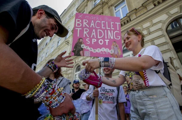 Des fans de Taylor Swift, appelés Swifties, échangent des bracelets dans le centre de Vienne le 8 août 2024, suite à l'annulation des concerts en raison d'un complot d'attentat planifié.