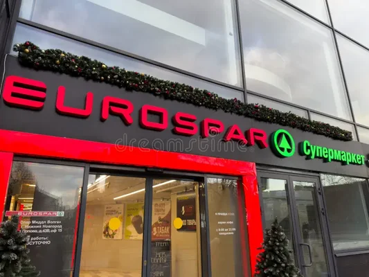 Extérieur d'un supermarché EUROSpar à Nijni Novgorod, en Russie, avec la signalisation rouge et verte de la marque, des guirlandes de fête au-dessus de l'entrée et des vitres couvertes d'affiches