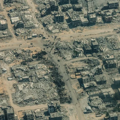 Vue aérienne de Gaza montrant un désert de débris, de poussière et de tombes, illustrant la dévastation dans la bande de Gaza.