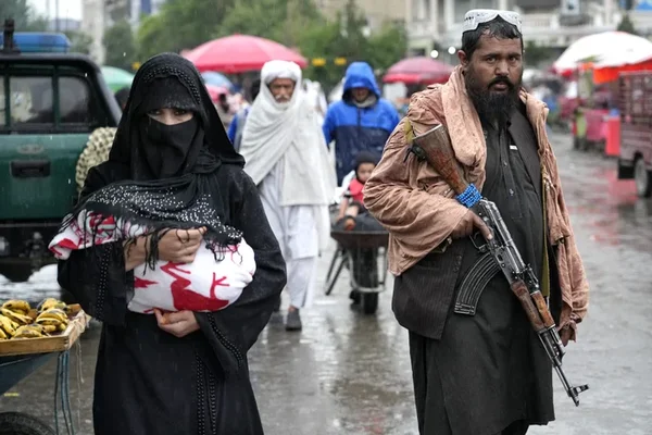 Une ancienne policière afghane mendiant dans la rue, montrant l'impact des politiques talibanes sur les droits et la vie des femmes un an après leur prise de pouvoir.