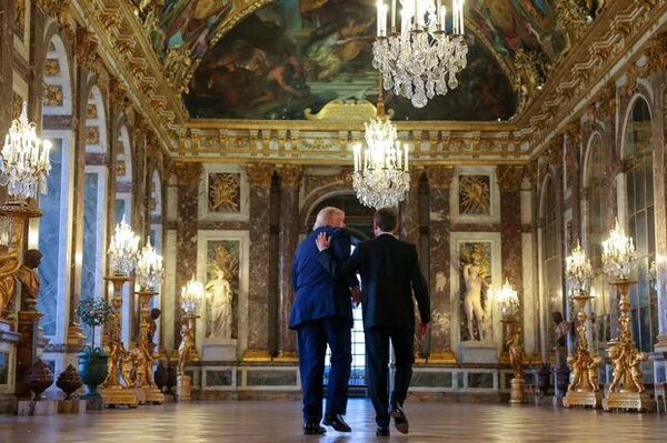 Donald Trump signant l'accord historique entre les États-Unis et l'Iran à Versailles, illustration des relations diplomatiques sur le Moyen-Orient.