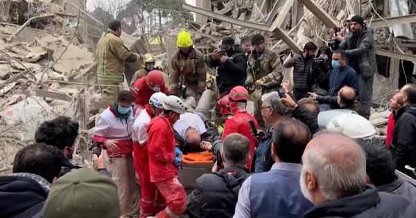 Secouristes d'urgence iraniens cherchant des survivants piégés sous les décombres suite aux frappes à Téhéran.