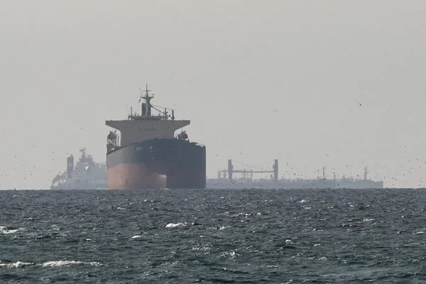 Pétroliers sous sanctions traversant le détroit d'Ormuz sous blocus américain, illustrant les tensions entourant le projet d'accord entre l'Iran et les États-Unis.
