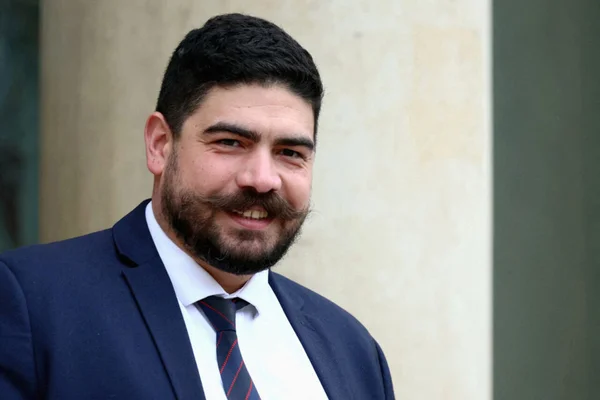 Guillaume Kasbarian, nouveau ministre de la Fonction publique, homme aux cheveux foncés et barbe, souriant en costume bleu foncé, chemise blanche et cravate rayée.