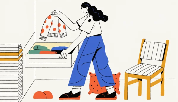 Jeune adulte debout près d'une commode ouverte, tenant un pull confortable pour préparer sa tenue de la semaine, dans une chambre simple, ambiance détendue.
