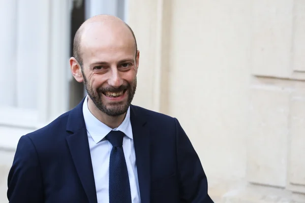 Stanislas Guerini, ministre de la Fonction publique, homme d'âge moyen souriant avec barbe et cheveux courts, veston bleu foncé, chemise bleu clair et cravate à motifs.