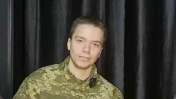 Jeune soldat russe aux cheveux bruns courts et à la barbe claire, portant un uniforme de camouflage, regardant l'objectif devant un rideau sombre, image liée à l'article sur la trahison ayant causé la mort de 150 Russes.