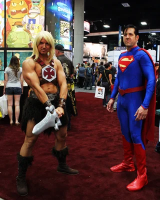 Cosplayeurs représentant He-Man de 'He-Man et les Maîtres de l'Univers' et Superman de DC Comics, debout sur un tapis rouge lors de la San Diego Comic-Con 2012.