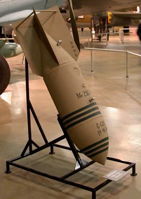 Bombe allemande de la Seconde Guerre mondiale de type SC 250, d'un poids de 250 kg, présentée sur un socle dans un musée, avec ses marquages et ailerons de queue visibles.