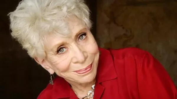Bunny Levine, ancienne bibliothécaire devenue actrice à la retraite, morte à 97 ans, femme âgée aux cheveux courts et bouclés blancs, portant une veste rouge et un collier en argent, souriant à l'appareil.