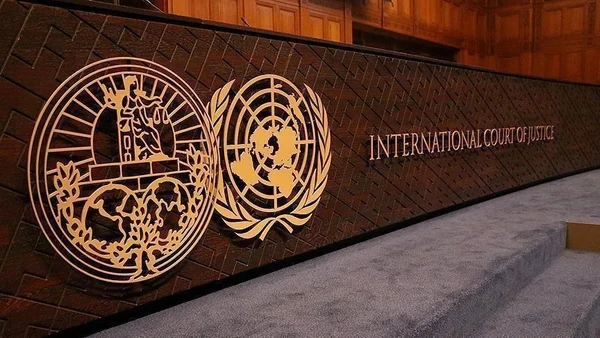 Panneau mural en bois présentant les emblemes dorés de la Cour internationale de justice et de l'ONU avec le texte 'INTERNATIONAL COURT OF JUSTICE', relatif au droit de grève.