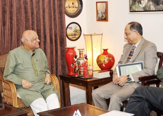 Kaushik Basu, économiste en chef de la Banque mondiale, et Abul Maal Abdul Muhith, ministre des Finances, assis lors d'une réunion à Dhaka le 14 décembre. Basu en costume gris tenant un dossier, Muhith en kurta vert et pantalon blanc, en conversation.