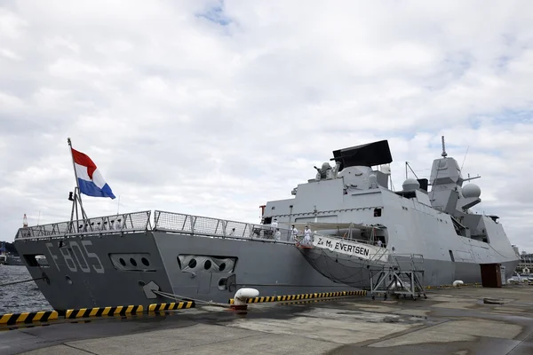 Frégate néerlandaise grise Zr. Ms. EVERTSEN (F805) amarrée à un quai, drapeau des Pays-Bas à la poupe, sujet de l'article sur la localisation d'un navire de guerre via un traceur Bluetooth de 5 euros caché dans une carte postale.