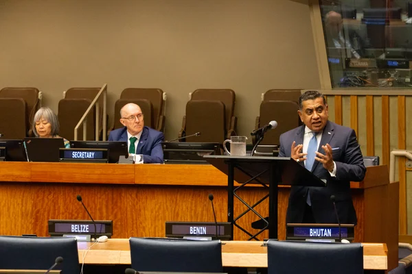 Session du 22 septembre 2023 au siège de l'ONU à New York : un homme en costume sombre et cravate bleu clair parlant au pupitre, devant les plaques Belize, Bénin et Bhoutan.