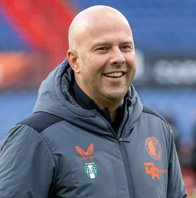 Arne Slot, homme chauve avec une légère barbe, souriant et portant une veste à capuche grise aux couleurs du Feyenoord Rotterdam, lors d'un match amical contre Go Ahead Eagles à Rotterdam le 15 novembre 2023.