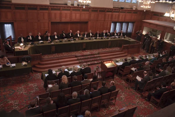 Vue en plongée du Grand Hall de justice du Palais de la Paix à La Haye, Pays-Bas, montrant juges en robes et avocats lors d'audience de la CIJ sur l'avis consultatif du Kosovo.
