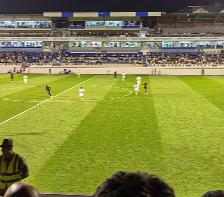 Vue large d'un match de football de nuit entre le Sabah FK et le PFC Levski Sofia lors d'un qualificatif de la Ligue Europa Conférence, montrant joueurs sur le terrain et spectateurs dans les tribunes.